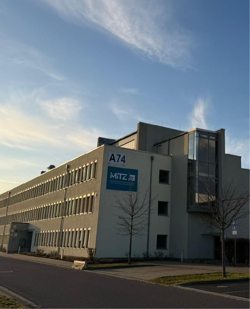 Luftaufnahme einer Kläranlage mit mehreren runden Becken und rechteckigen Filtrationsbecken.